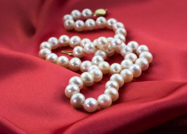 Collar de perlas en satén rojo — Foto de Stock