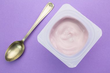 Healthy strawberry fruit flavored yoghurt with natural coloring in a plastic up top view clipart