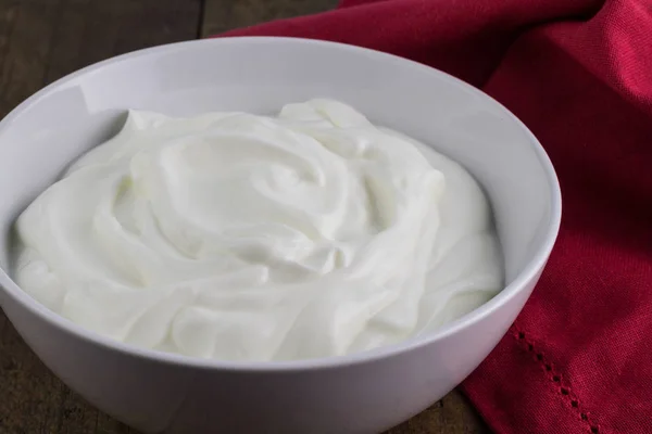 Натуральный йогурт в белой керамической миске — стоковое фото