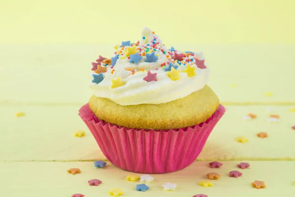 Одиночная ванильная губка день рождения кекс с глазурью и покрыты звездными брызгами — стоковое фото