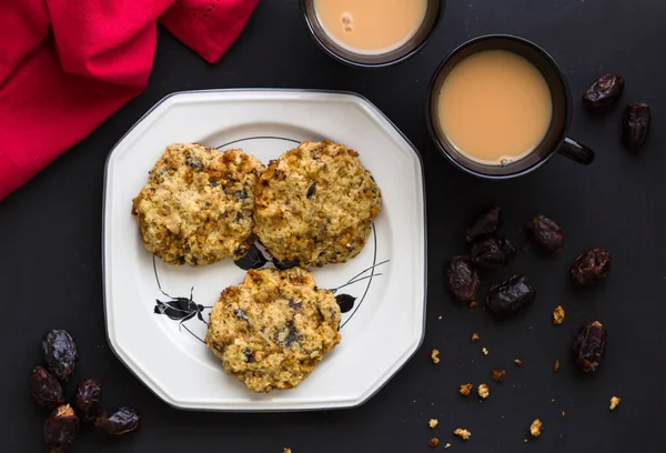 Galletas de avena y fruta dátiles en elegante plato blanco con dos tazas de té — Foto de Stock