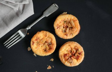 Kokulu Mini quiches çatal ile siyah masada