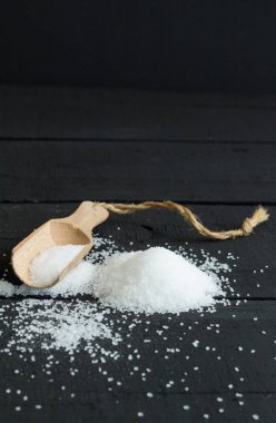 Rustik siyah tablo arka plan üzerinde tuz ve ahşap Kepçe