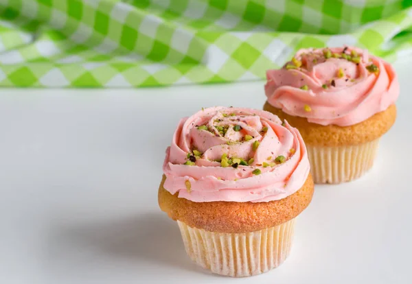 Zwei rosa rose wirbelte mattierte Cup Cakes mit Pistazie sprin — Stockfoto