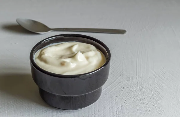 Yogur en taza negra sobre fondo gris con espacio para texto —  Fotos de Stock