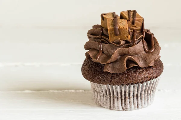 Cupcake au chocolat décoré de mini carrés de fudge sur rus blanc — Photo