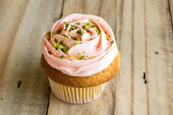 Rosa Tasse Kuchen auf rustikalem Holztisch in Großaufnahme — Stockfoto