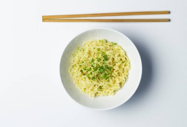 Bambu çubuk ile beyaz arka plan üzerinde beyaz kase erişte