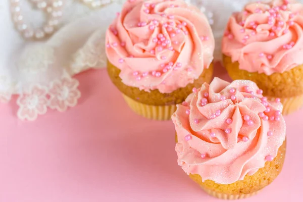 Pink glitter and pearl decorated cup cakes close up on pink back — Stock Photo, Image