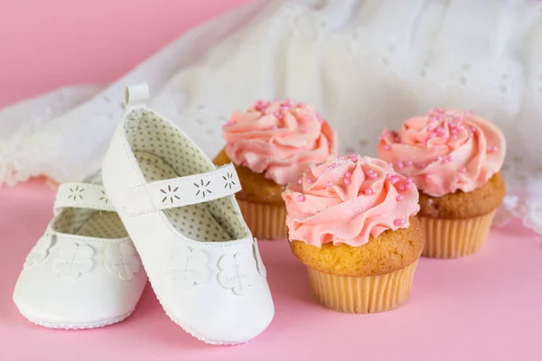 洗礼や誕生日の女の子招待カップ ケーキをピンクとピンクの背景の白い靴 — ストック写真