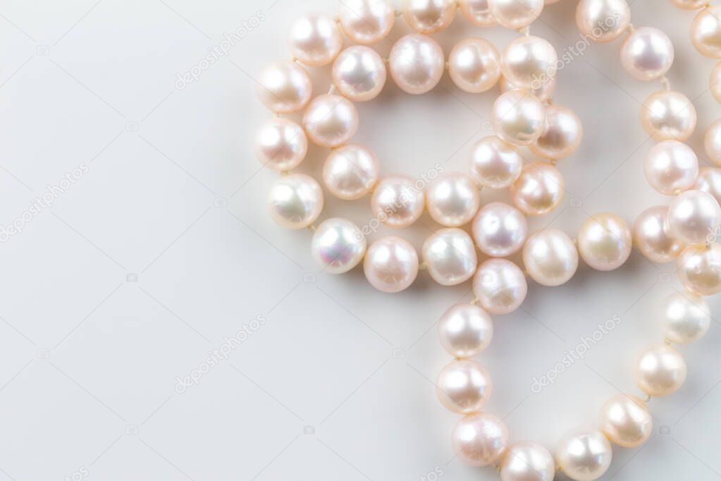 Pink pearl necklace isolated on white background - top view photo