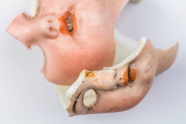 Kırık bebek yüzleri, beyaz arka planda izole edilmiş bir şekilde yakın plan.