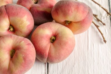 Donut peaches on white rustic table - horizontal closeup image with selective focus clipart