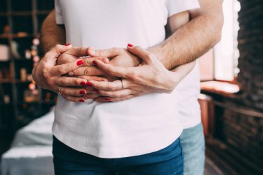 Nişan yüzüğü ile kızın eller, adam onun kızın arkasından, gelin ve damat hugs..