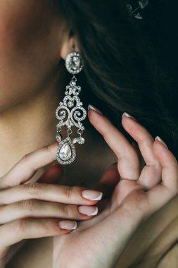 Gelin, küpe, güzel küpeler ve gelinin ellerini düzeltir..