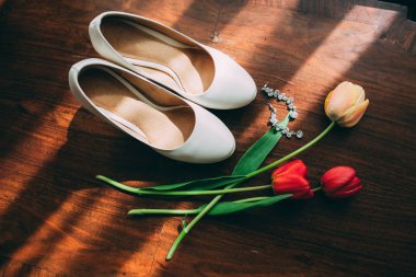Beyaz ayakkabı gelinin. Küpe ve laleler.