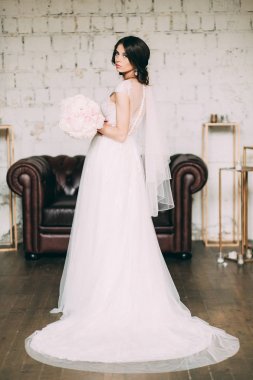 Gelin gelinlik Studio elinde güzel bir buket peonies ve gül ile tutar.