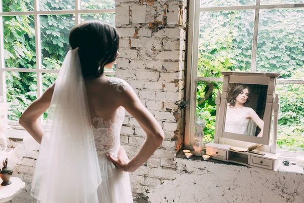 Kind of bride from the back, romantic atmosphere of the bride\'s morning, Portrait of the bride in the mirror by the window