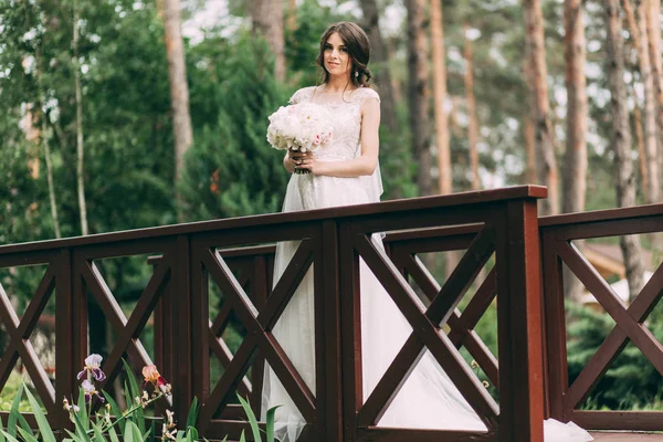 Noiva Vestido Noiva Segurando Buquê Nas Mãos Está Uma Ponte — Fotografia de Stock