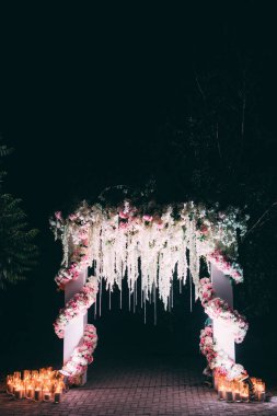 Düğün kemer çiçeklerle bezenmiştir. Gece sahne.