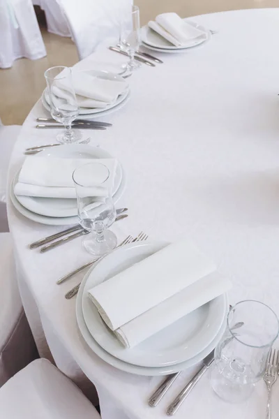 Wedding table with appliances. White tablecloth.