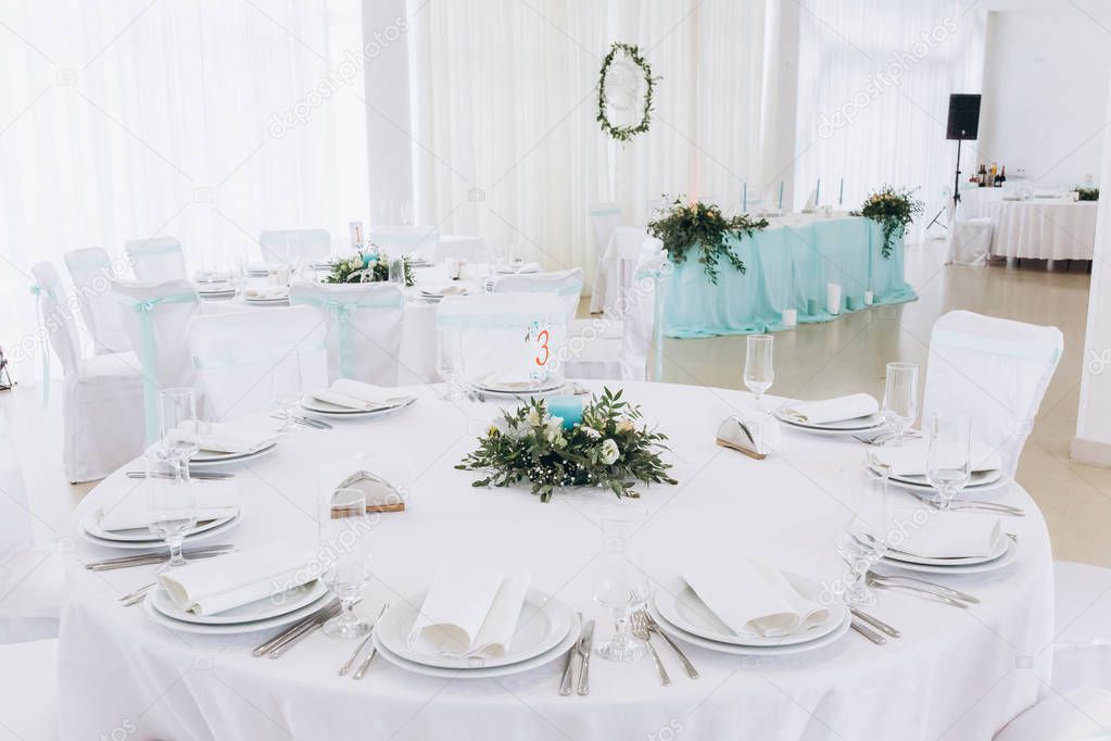 a wedding table with cutlery, candles and flowers.