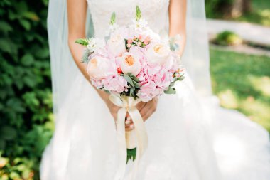 Bir gelin beyaz elbiseli güzel düğün buket tutuyor.