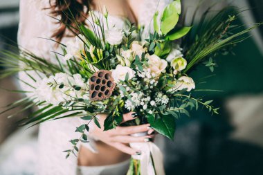 Bir gelin beyaz elbiseli güzel düğün buket tutuyor.