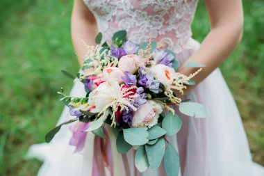 Bir gelin beyaz elbiseli güzel düğün buket tutuyor.