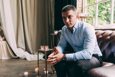 Deri koltuk üzerinde bir gömlekli bir adam portresi. Erkek portre. Deri koltukta oturan bir adam portresi.