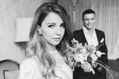 Gelin ve damat toplantı. Gelin Damat için bekliyor. Gelin Damat arka planda bir buket çiçek ile portresi.