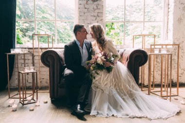 Gelin ve damat. Gelin ve damat birlikte kanepede oturuyorsun. Gelin ve damat silah.