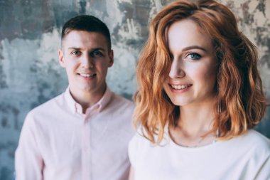 Bir adamla bir kız stüdyoda. Kızıl saçlı bir kız portresi.