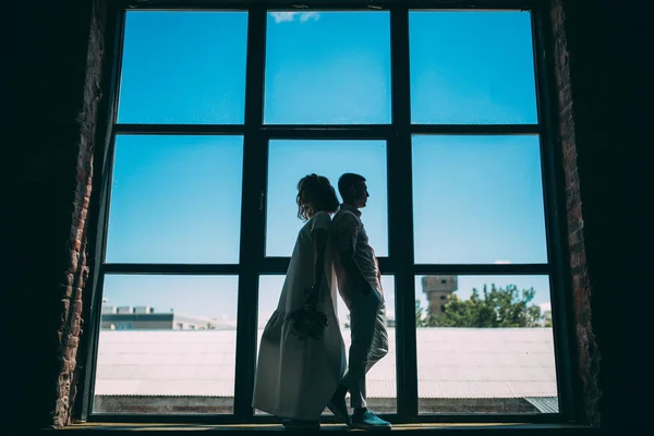 A guy with a girl in the studio. Romantic meeting by the window.