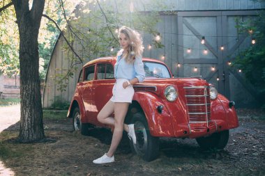 kızın yanında eski bir kırmızı araba