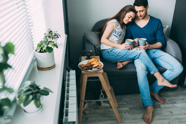 A photo session of a guy and a girl in a cozy home environment.