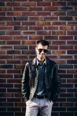 Kahverengi tuğla duvar arka plan üzerinde bir adam portresi.
