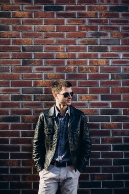 Kahverengi tuğla duvar arka plan üzerinde bir adam portresi.