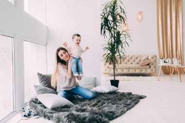 Genç bir annenin kızı rahat bir ev ortamı ile fotoğraf çekimi.