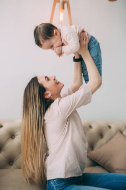 Genç bir annenin kızı rahat bir ev ortamı ile fotoğraf çekimi.