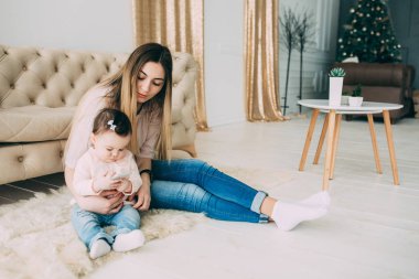 Genç bir annenin kızı rahat bir ev ortamı ile fotoğraf çekimi.