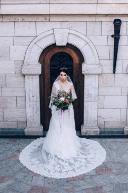 Bir gelin beyaz elbiseli güzel düğün buket tutuyor.