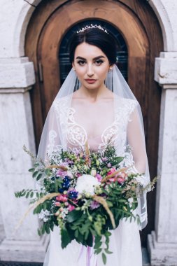 Bir gelin beyaz elbiseli güzel düğün buket tutuyor.