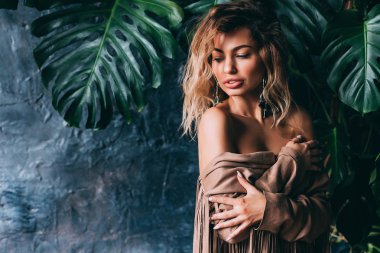 Bir genç kız siyah iç çamaşırı ve kahverengi pelerin portresi.