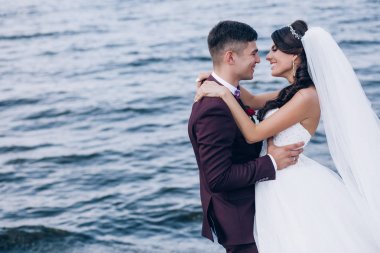 Yeni evliler deniz kenarında yürüyüş.