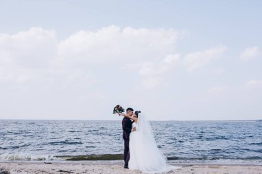 Yeni evliler deniz kenarında yürüyüş.