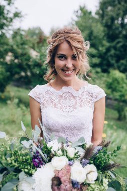 Bir gelin beyaz elbiseli güzel düğün buket tutuyor.