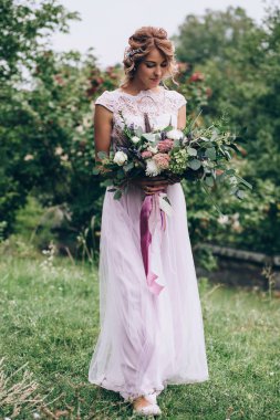 Bir gelin beyaz elbiseli güzel düğün buket tutuyor.