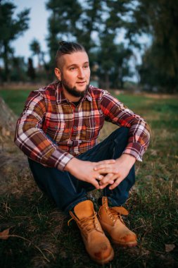 Doğada sakallı genç bir adam portresi.