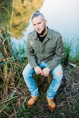 Doğada sakallı genç bir adam portresi.